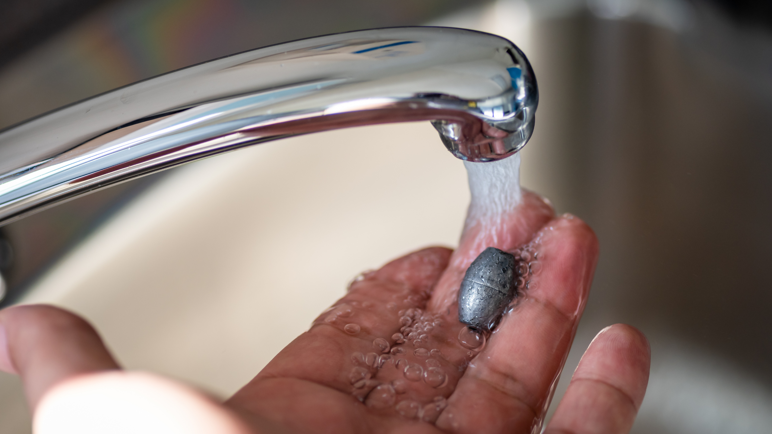 Tap water on heavy metal in hand